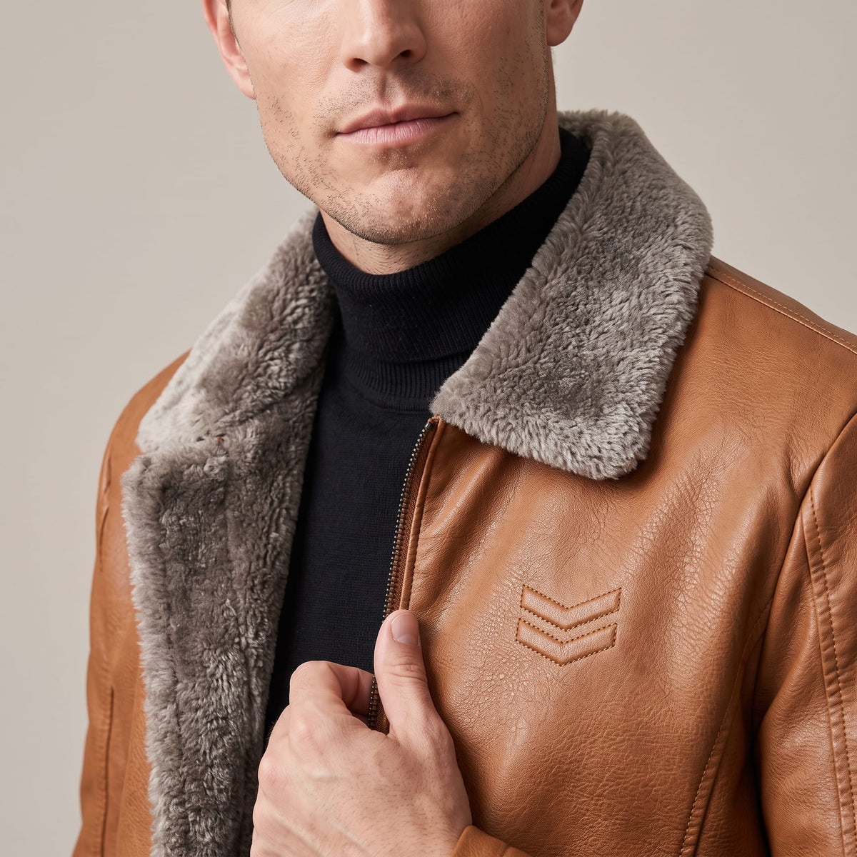 Close-up of a man wearing a brown leather shearling jacket, showing the plush collar and full-zip front