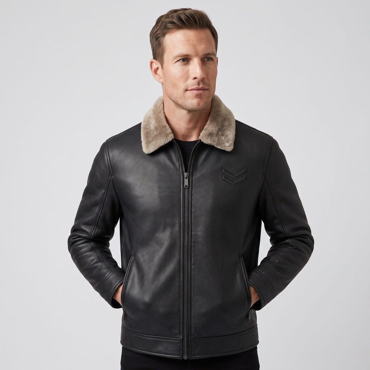 A man wearing a black leather shearling jacket with a plush collar and full-zip front