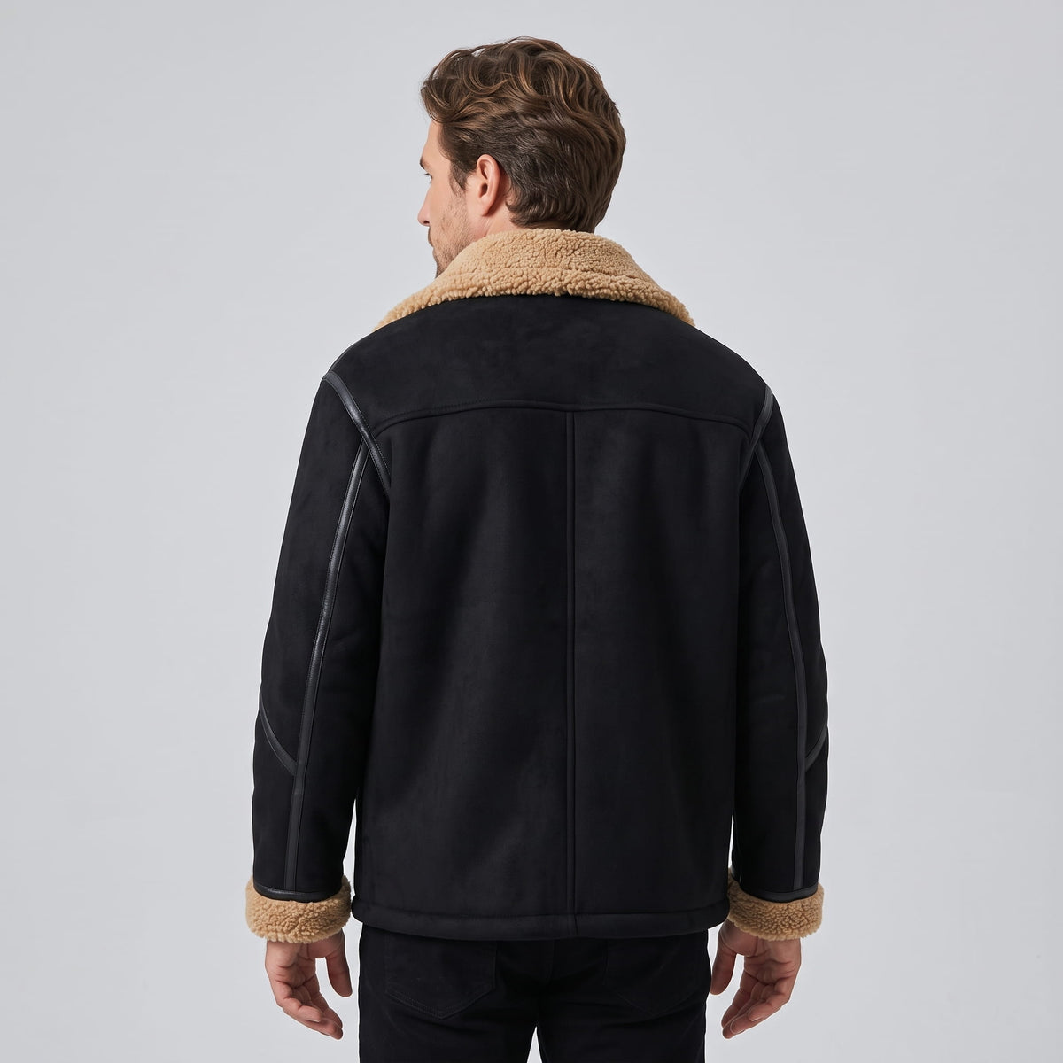 A man wearing a black leather shearling jacket with sherpa lining, shown from the back