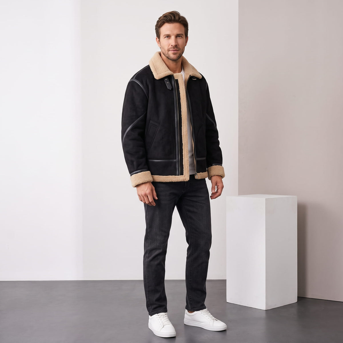 A man wearing a black leather shearling jacket with sherpa lining and a notched collar, full-length view
