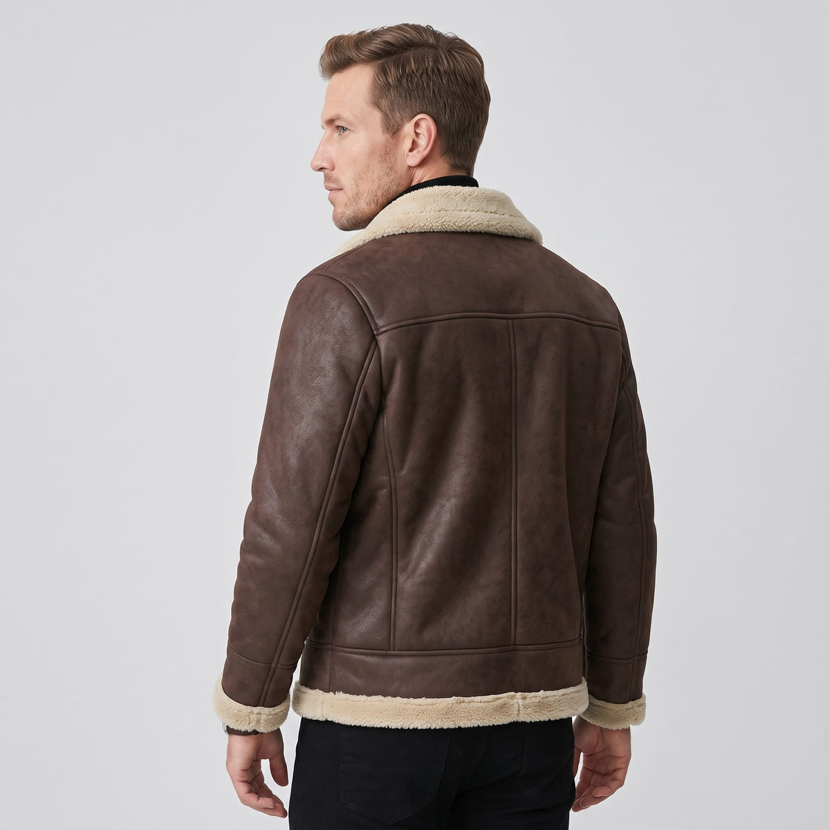 A man wearing a dark  brown leather sherpa aviator jacket with fleece lining, shown from the back