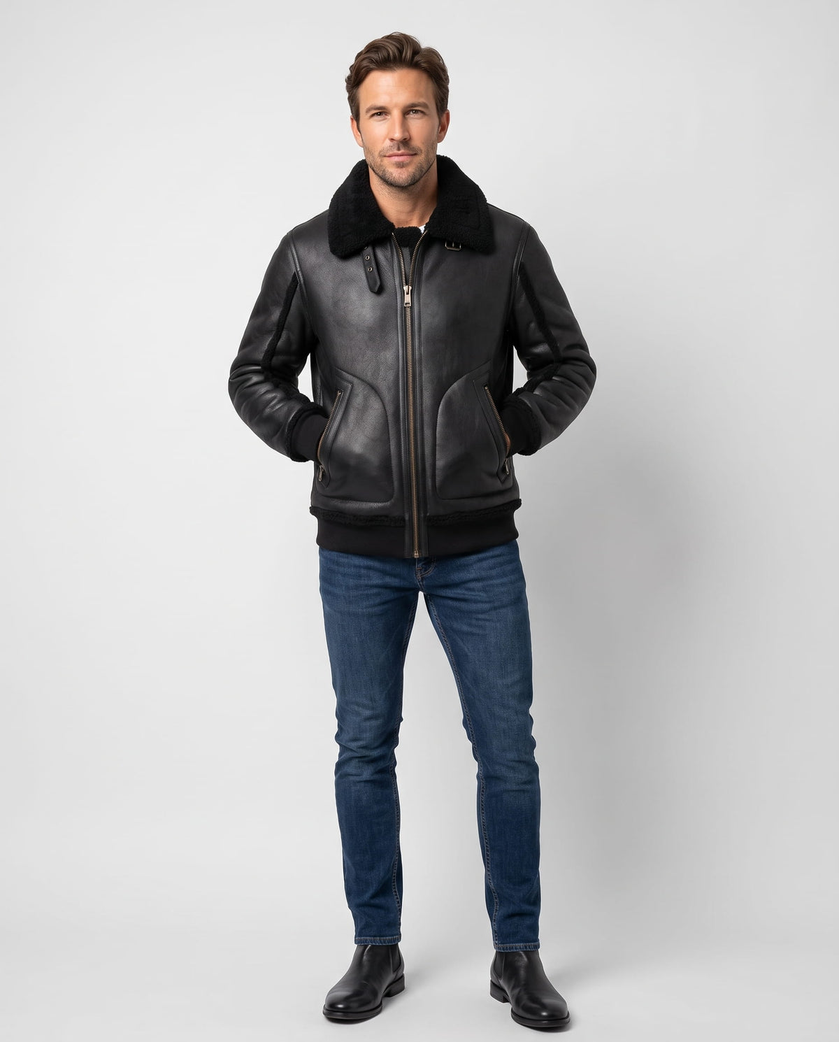 A man wearing a black leather sherpa aviator jacket with a wide collar and ribbed trim, full-length view