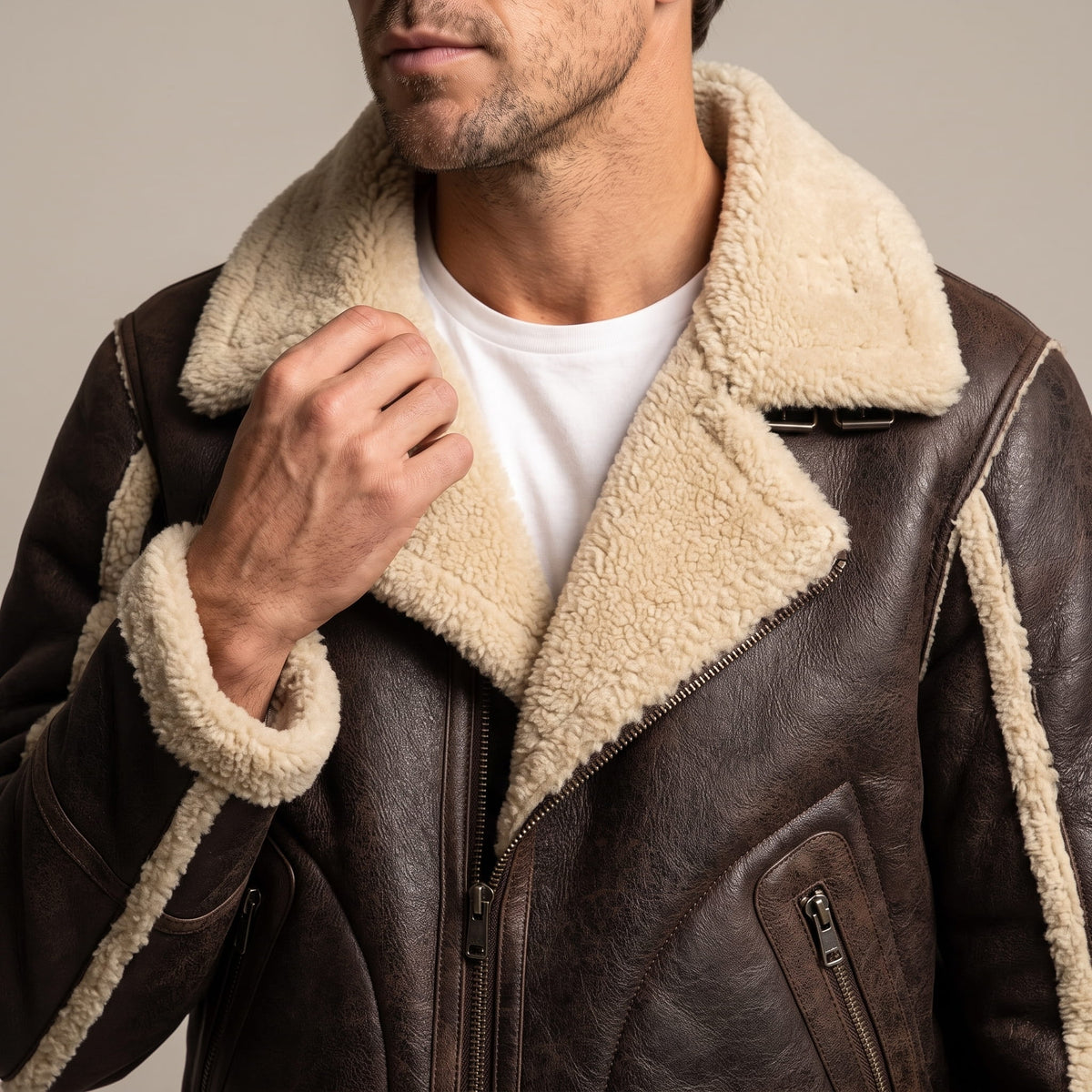 Close-up of a brown leather sherpa aviator jacket showing the wide sherpa collar and ribbed trim