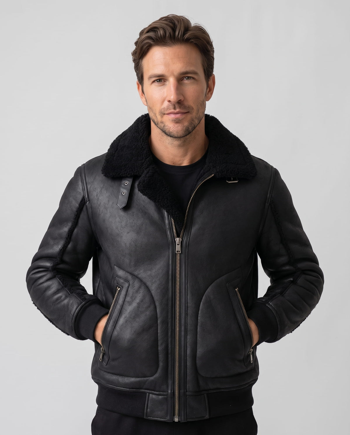 A man wearing a black leather sherpa aviator jacket with a wide collar and ribbed trim, front view