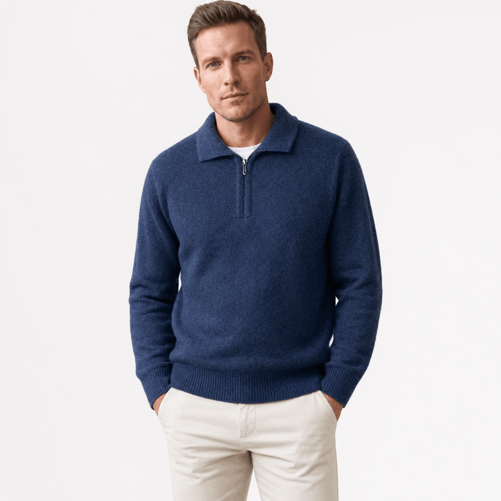 Man wearing a navy blue textured half-zip sweater with light-colored pants.