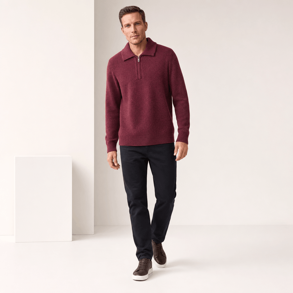 Full-body view of the man wearing the burgundy half-zip sweater with dark pants.