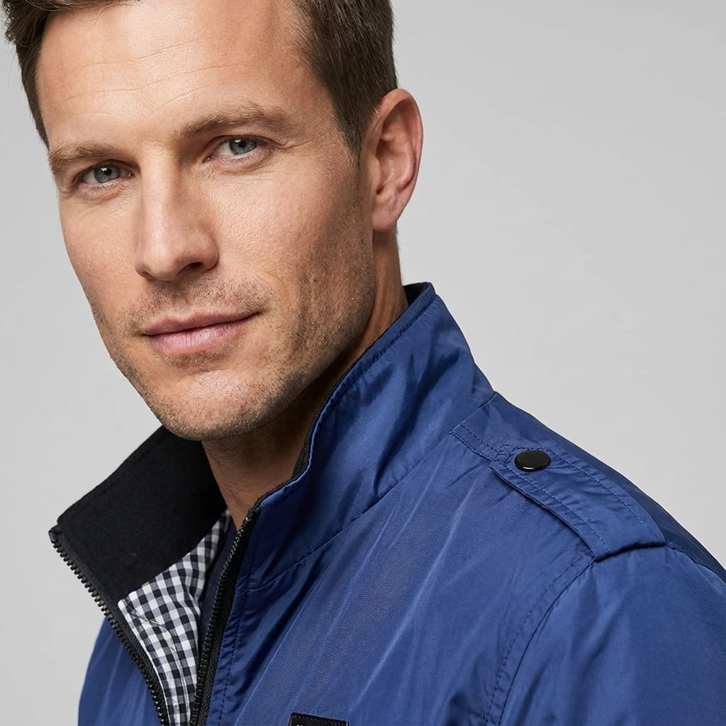 Close-up of the navy blue bomber jacket, showing the collar, shoulder, and sleeve details.