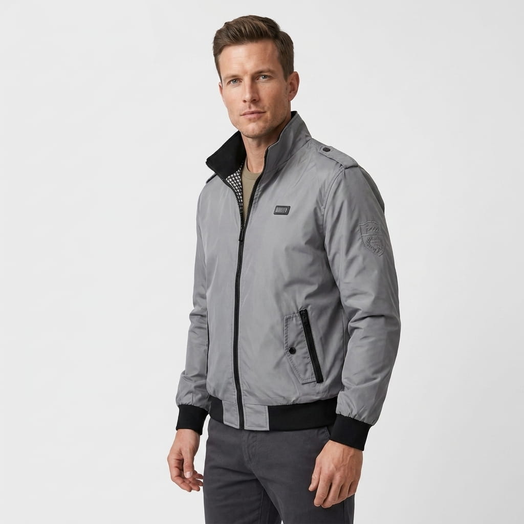 Man wearing a light gray zip-front bomber jacket with a black stand collar and black ribbed cuffs and hem.