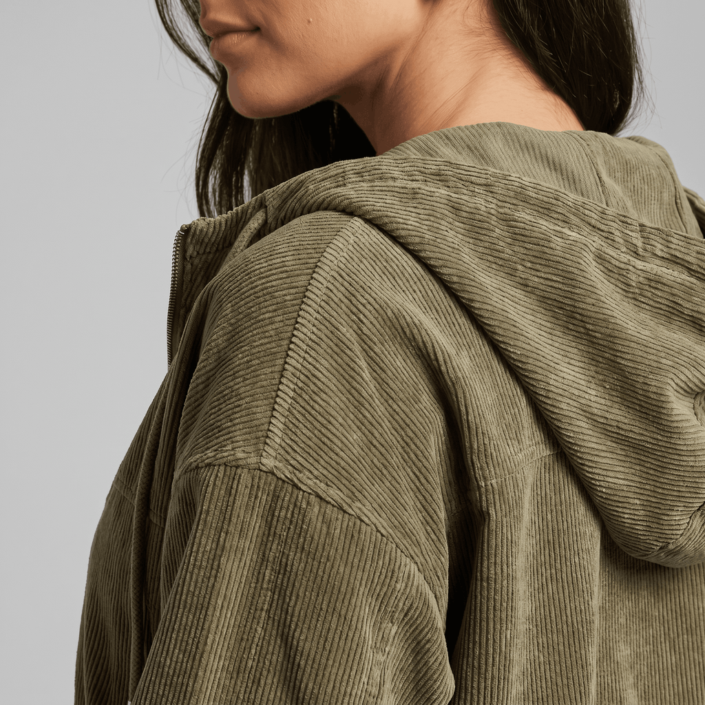 Olive green corduroy zip-up hoodie with a soft ribbed texture, oversized fit, and adjustable drawstring hood.