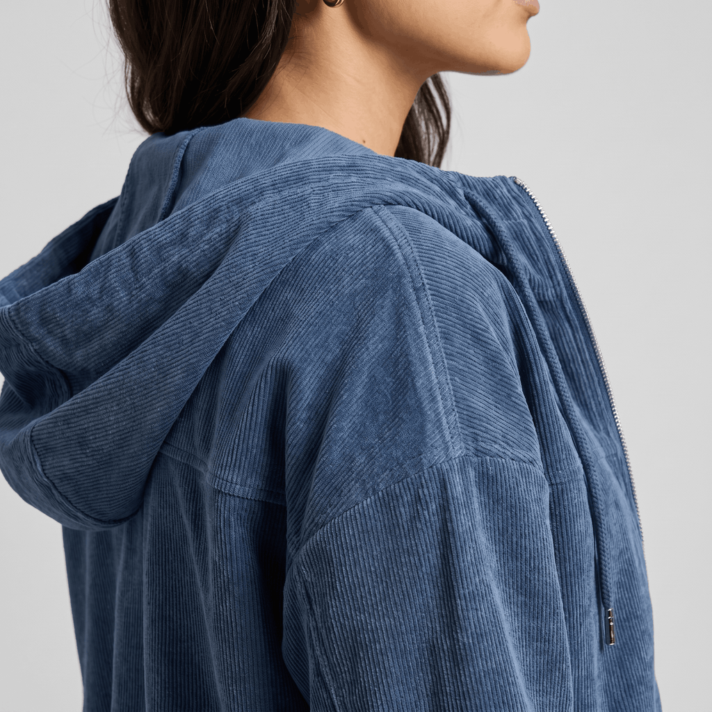 Washed blue corduroy zip-up hoodie with a soft wale texture, oversized fit, and silver hardware against a neutral background.