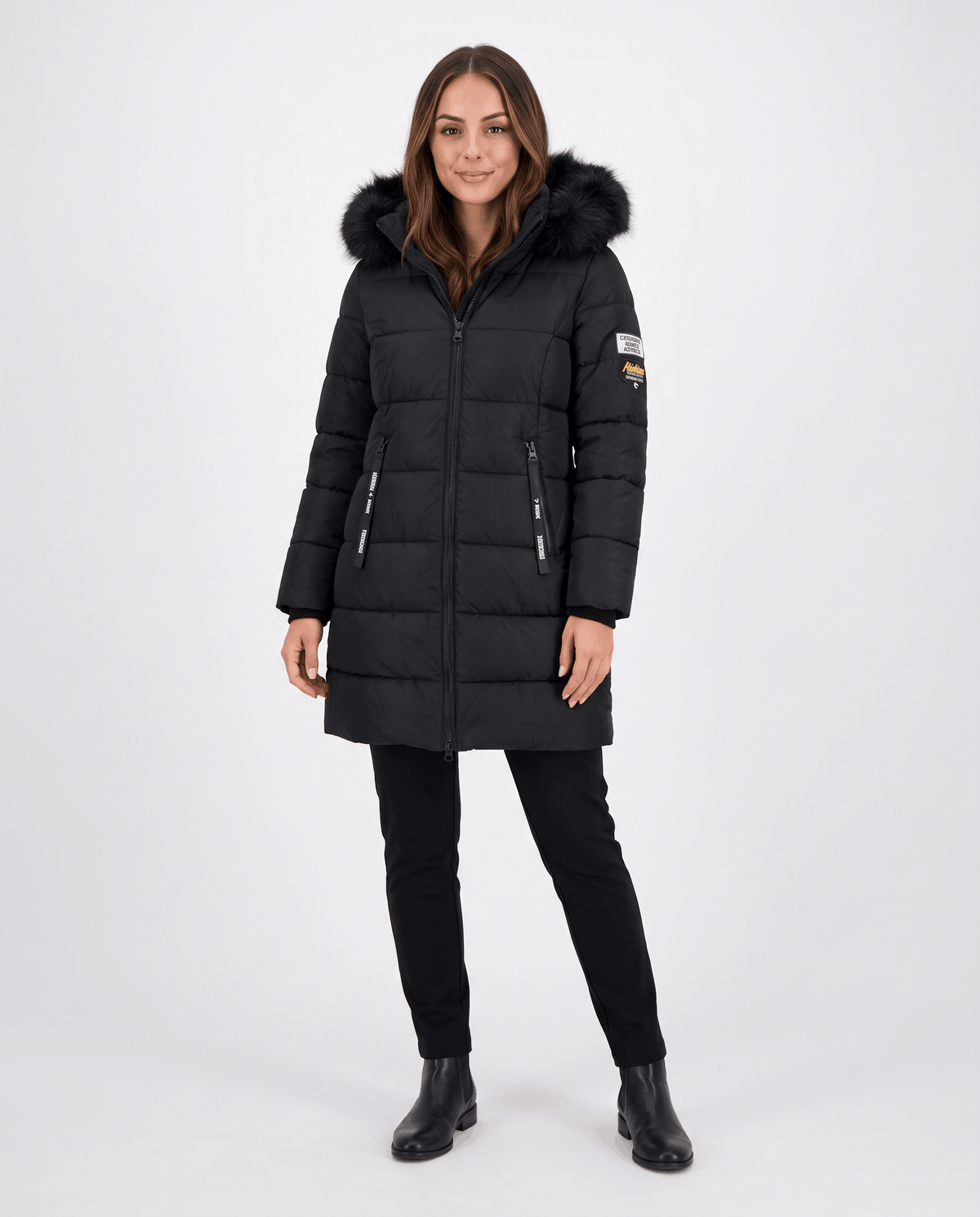 A woman wearing a black long insulated parka jacket with a hood and full-zip front