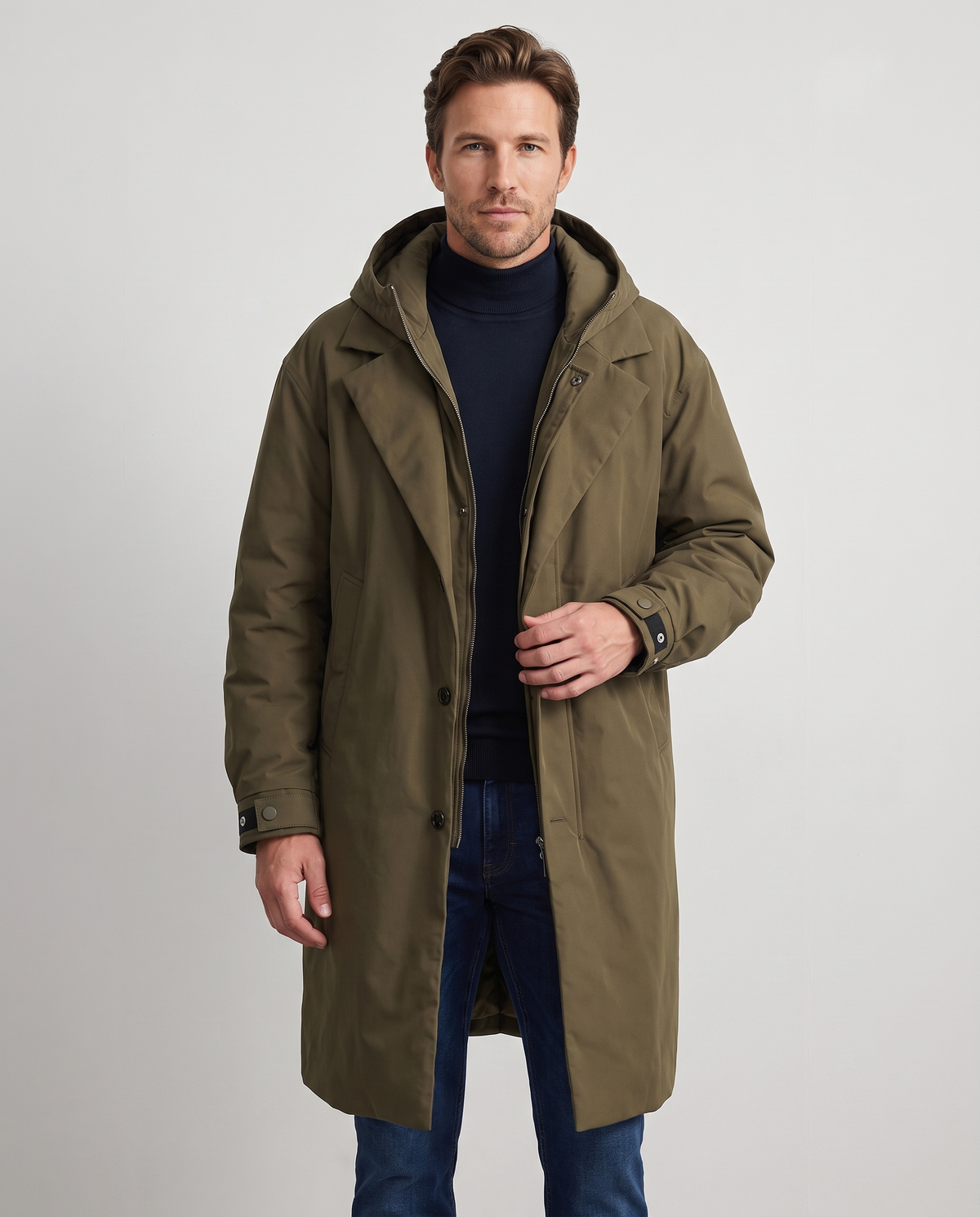 Olive green hooded long coat with notched lapels, zip closure, and button details worn by a male model