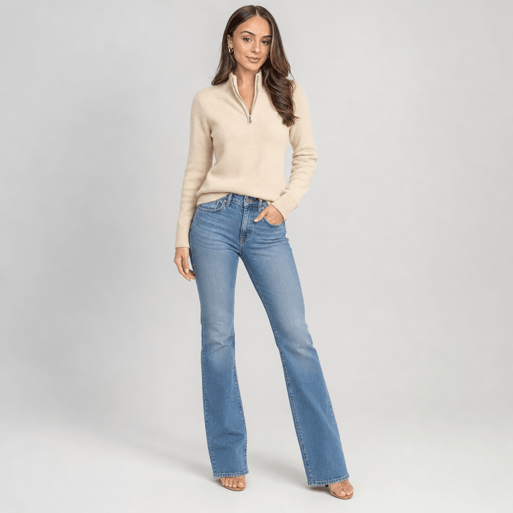 Full-body view of the woman wearing the cream half-zip sweater with light-colored pants.