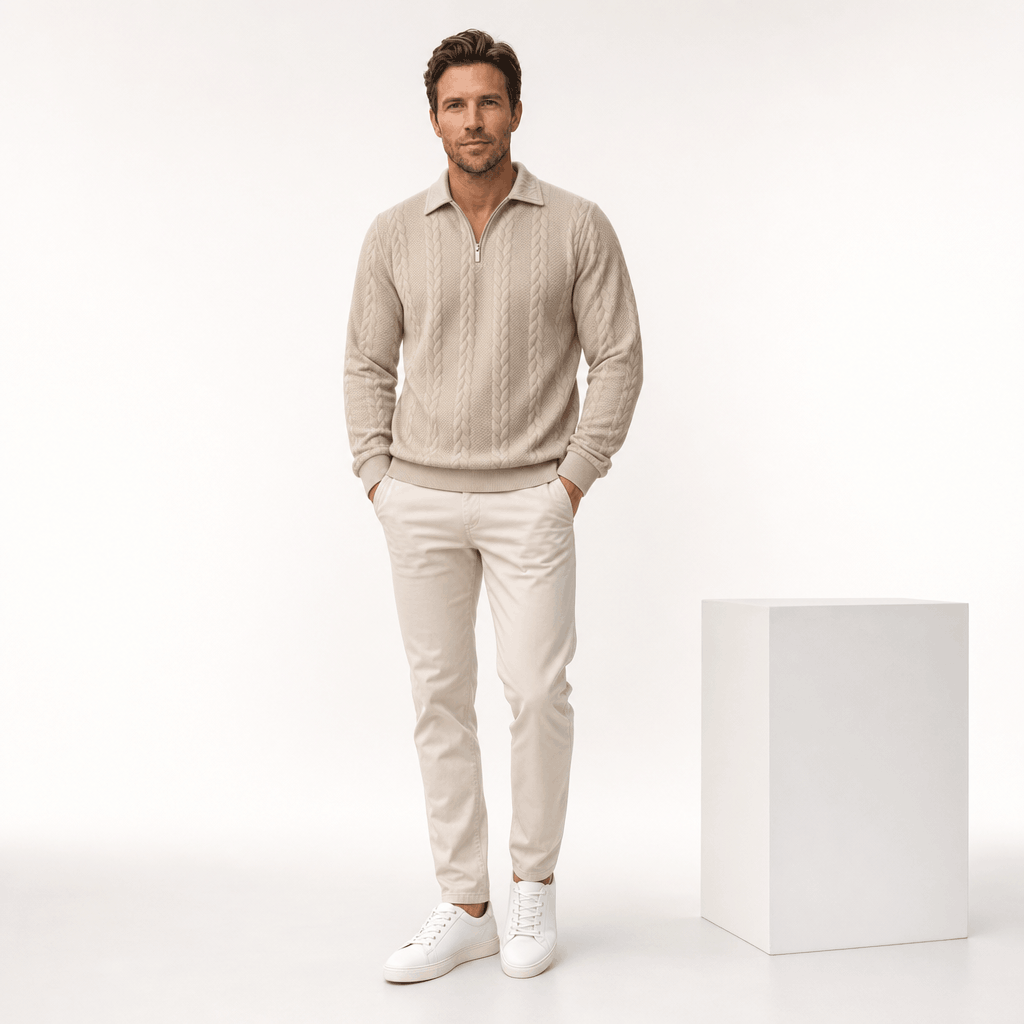 Man wearing the light beige quarter-zip cable-knit sweater with matching light trousers and white sneakers.