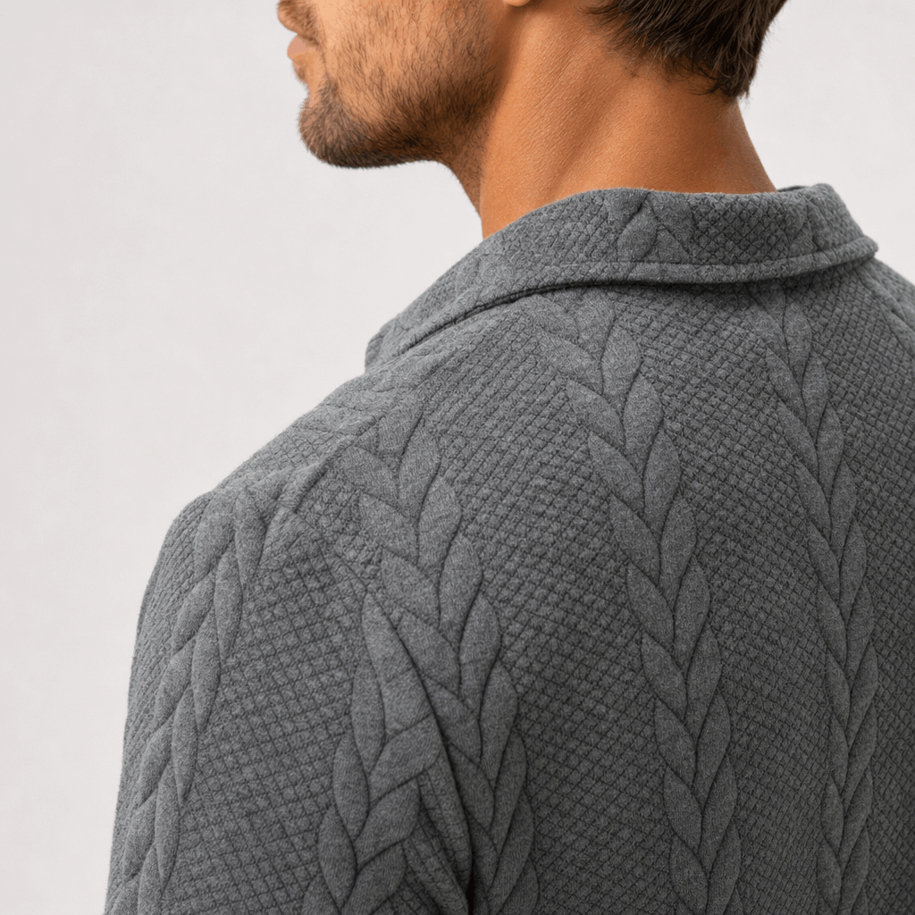 Grey cable-knit quarter-zip sweater with a textured jacquard pattern, structured point collar, and tailored fit.