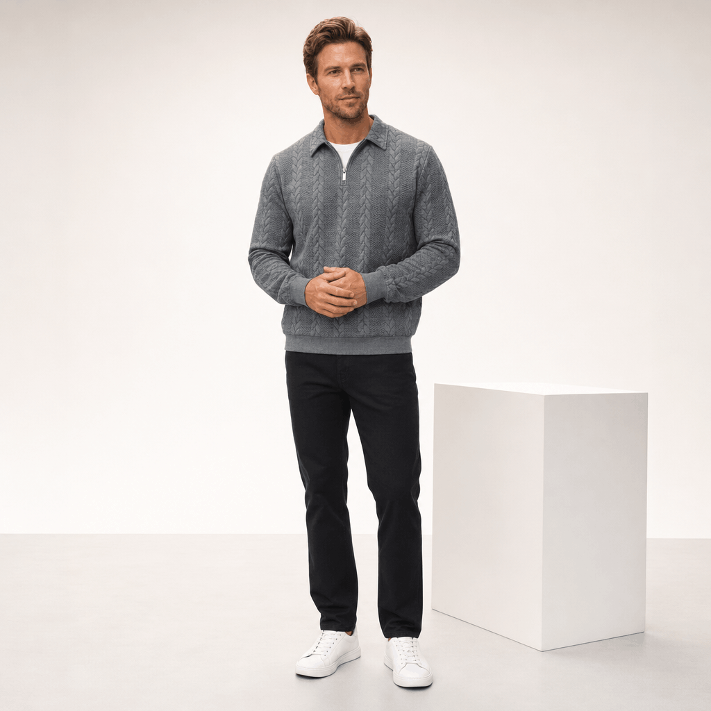 Grey cable-knit quarter-zip sweater with a point collar, ribbed cuffs, and hem, styled with black trousers and sneakers.