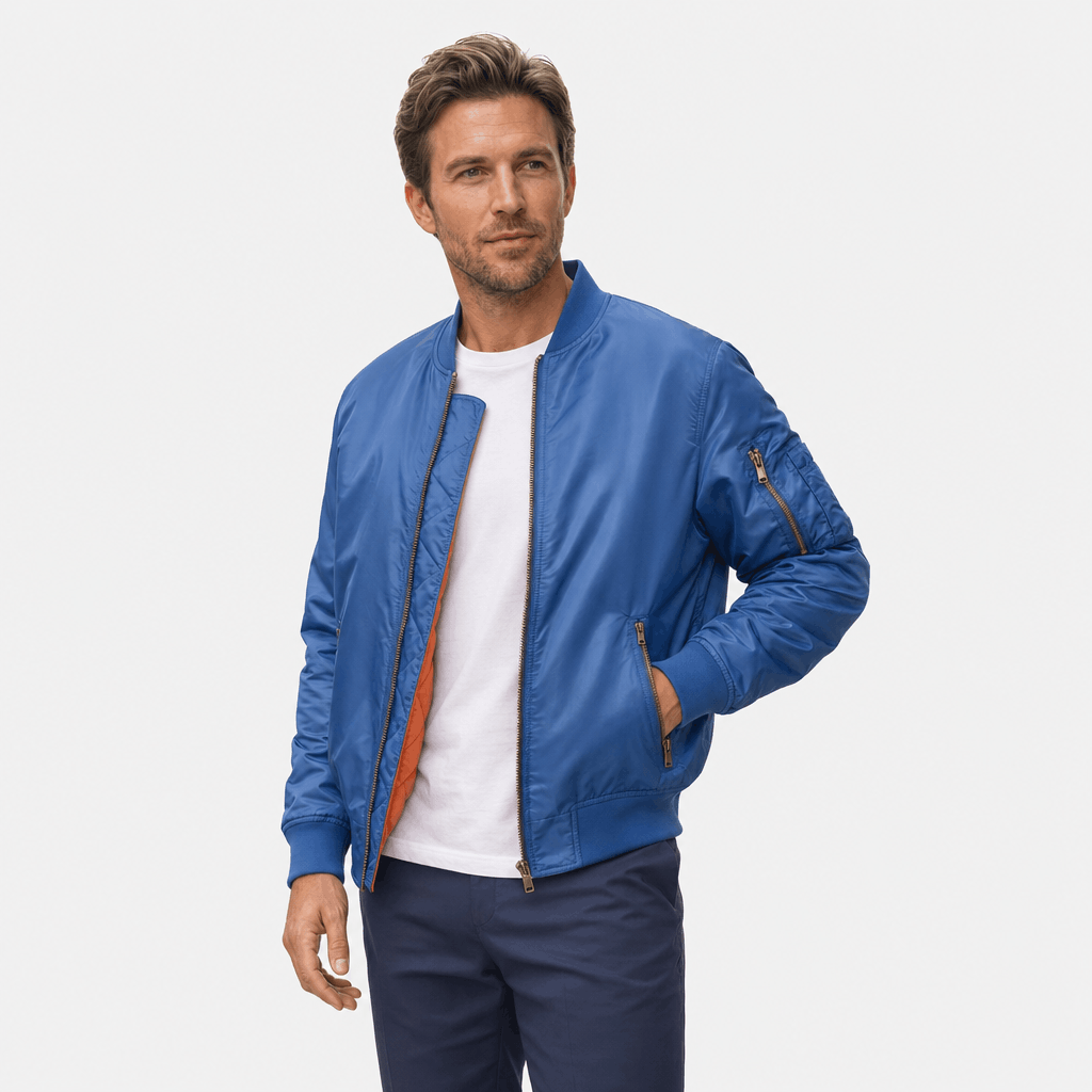 Male model wearing a blue bomber jacket over a white shirt.