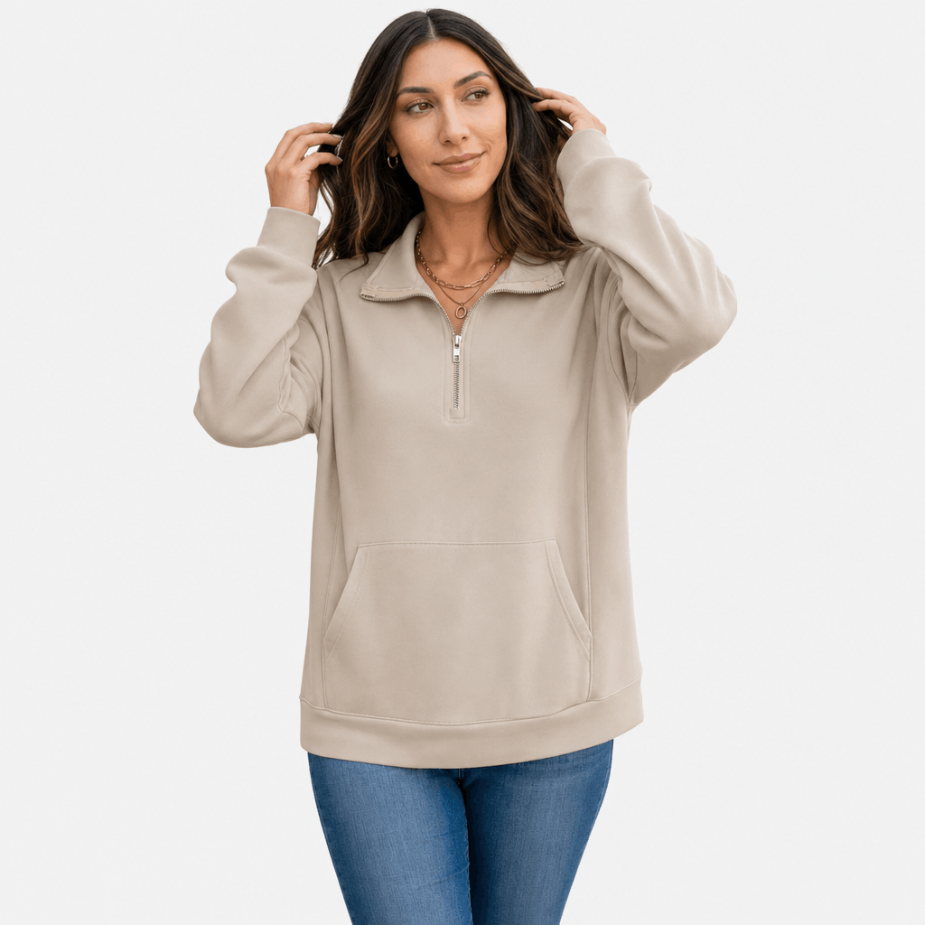 Female model wearing the light taupe quarter-zip sweater, adjusting her hair in a casual pose.