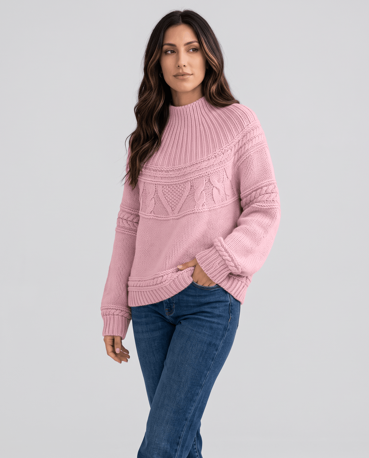 Pink Merino Wool Cable Knit Sweater worn by a female model with blue jeans, featuring a relaxed fit, textured cable knit pattern, high neckline, and ribbed trim.