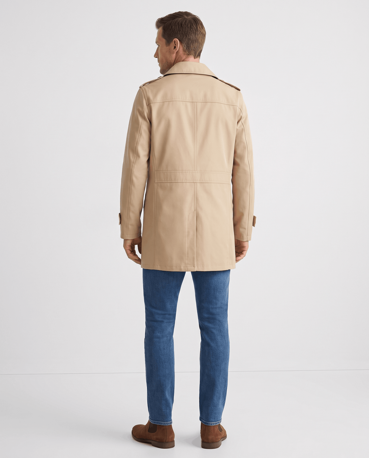 A man wearing a beige mid-length single-breasted trench coat, shown from the back