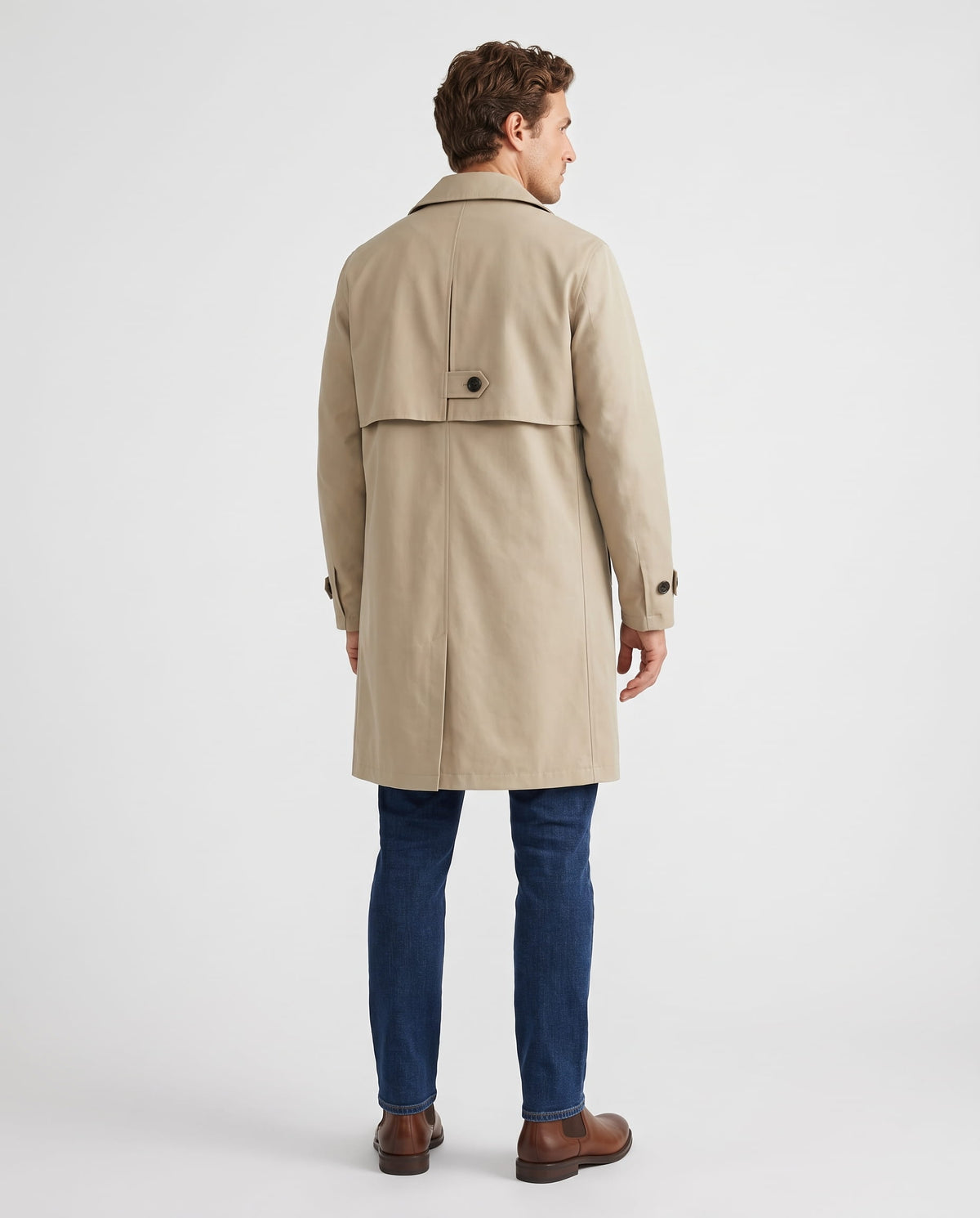 A man wearing a beige mid-length single-breasted trench coat with clean lines, shown from the back