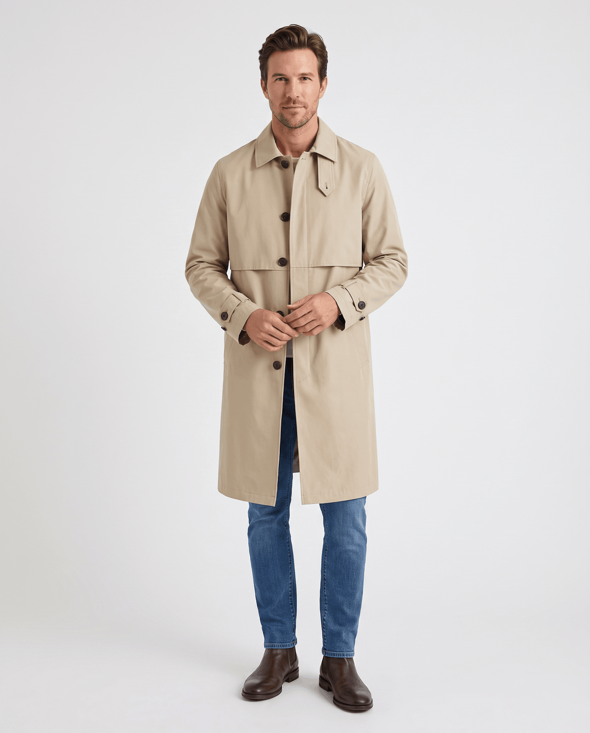 A man wearing a beige mid-length single-breasted trench coat with clean lines, a button front, and an easy layering fit