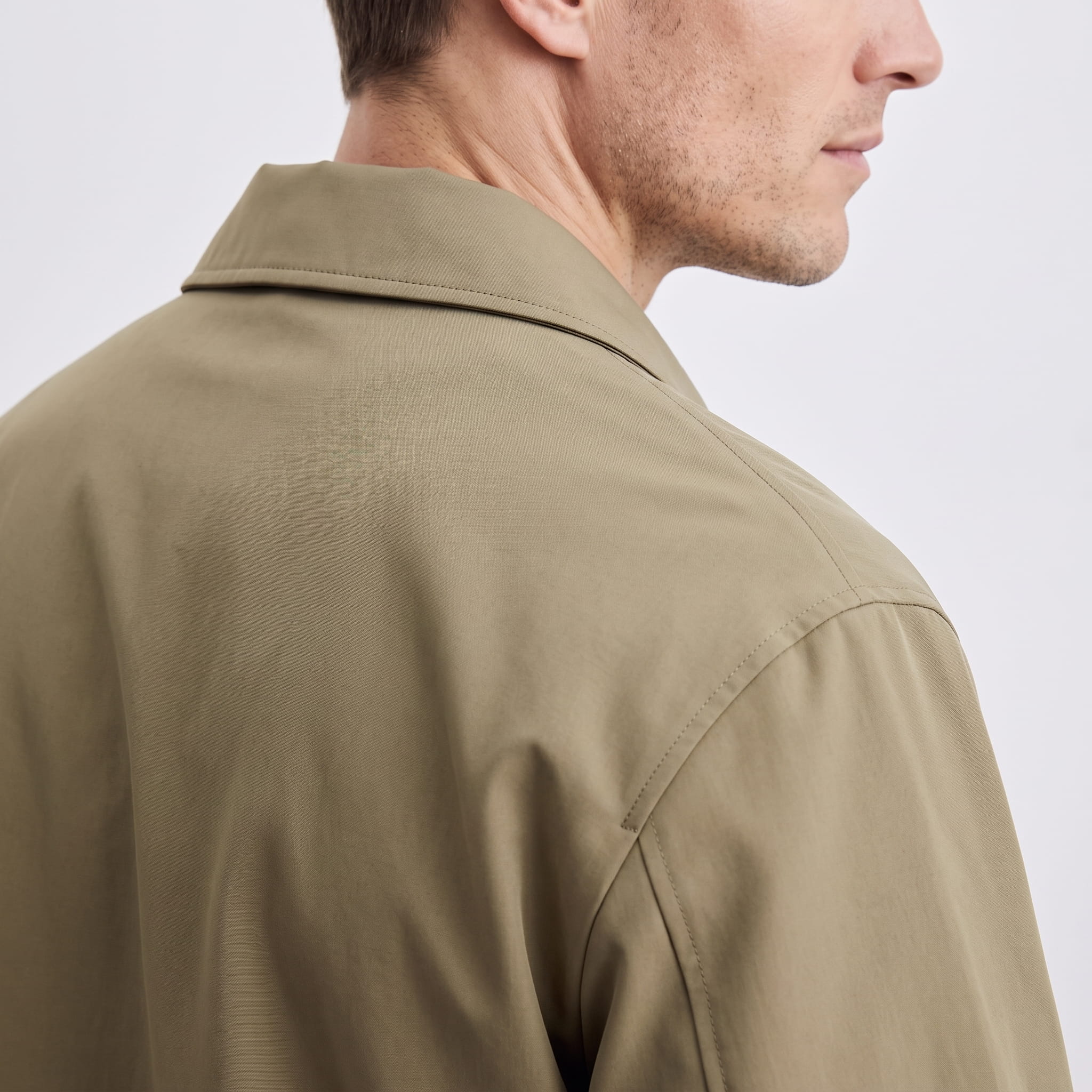 Side and back close-up showing the collar and shoulder of the khaki jacket.