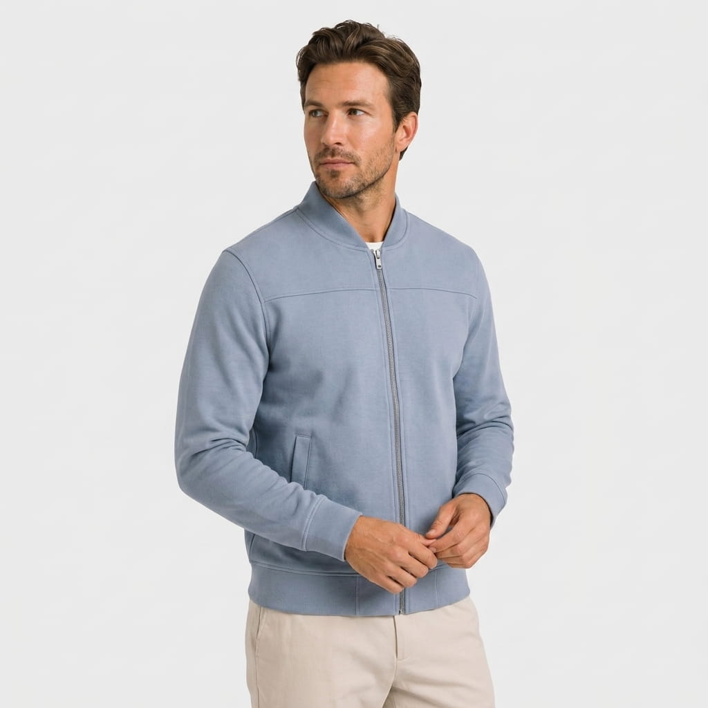 Male model wearing a light blue zip-up jacket with a stand collar and beige trousers.