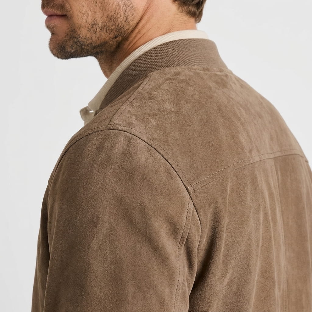Close-up side and back view of a brown zip-up jacket, highlighting the collar and shoulder seams.