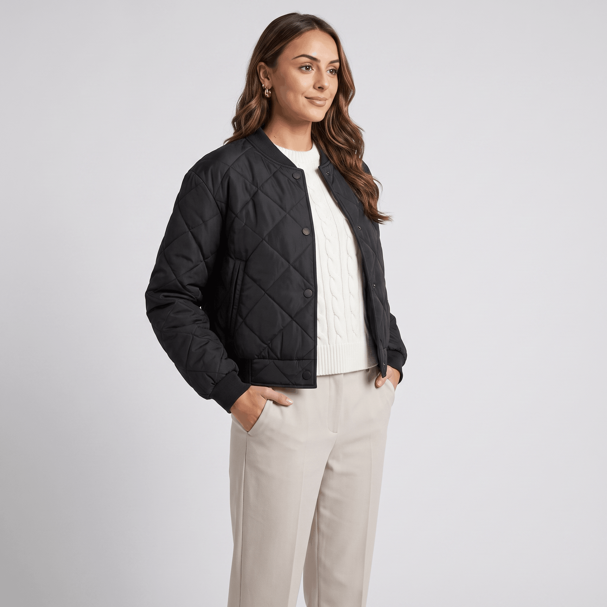 Female model wearing the black quilted jacket with light-colored trousers.