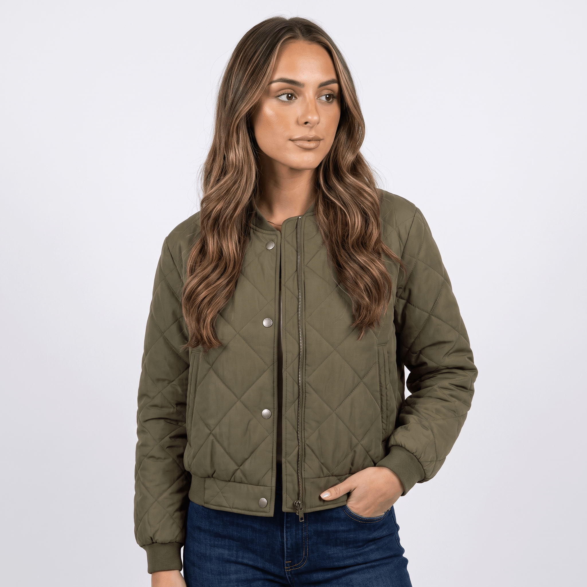 Female model wearing an olive green quilted jacket with blue jeans.