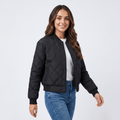 Female model wearing a black quilted zip-up jacket over a white top, paired with blue jeans.