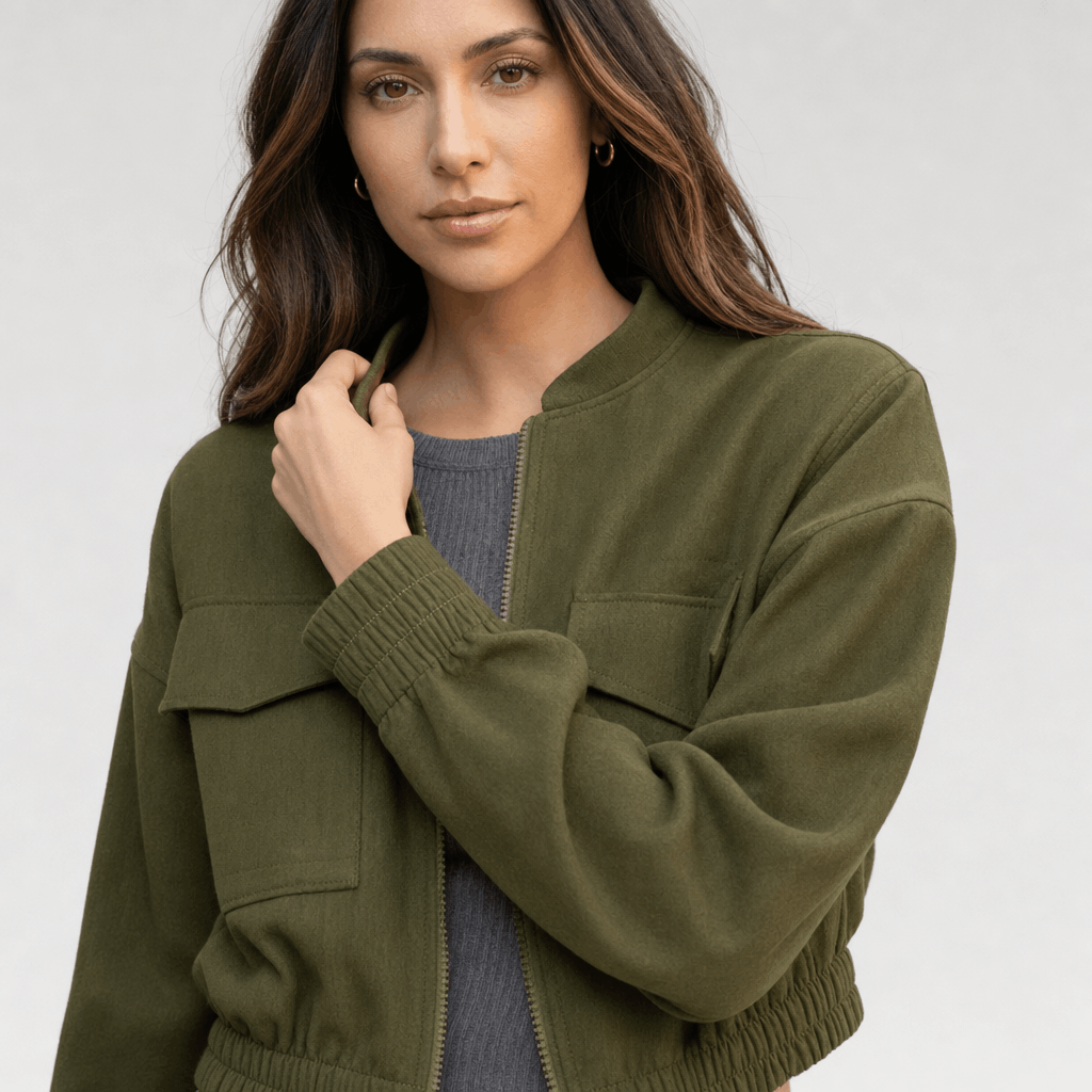 Female model wearing the olive green jacket, highlighting the stand collar, front zipper, and chest pocket.