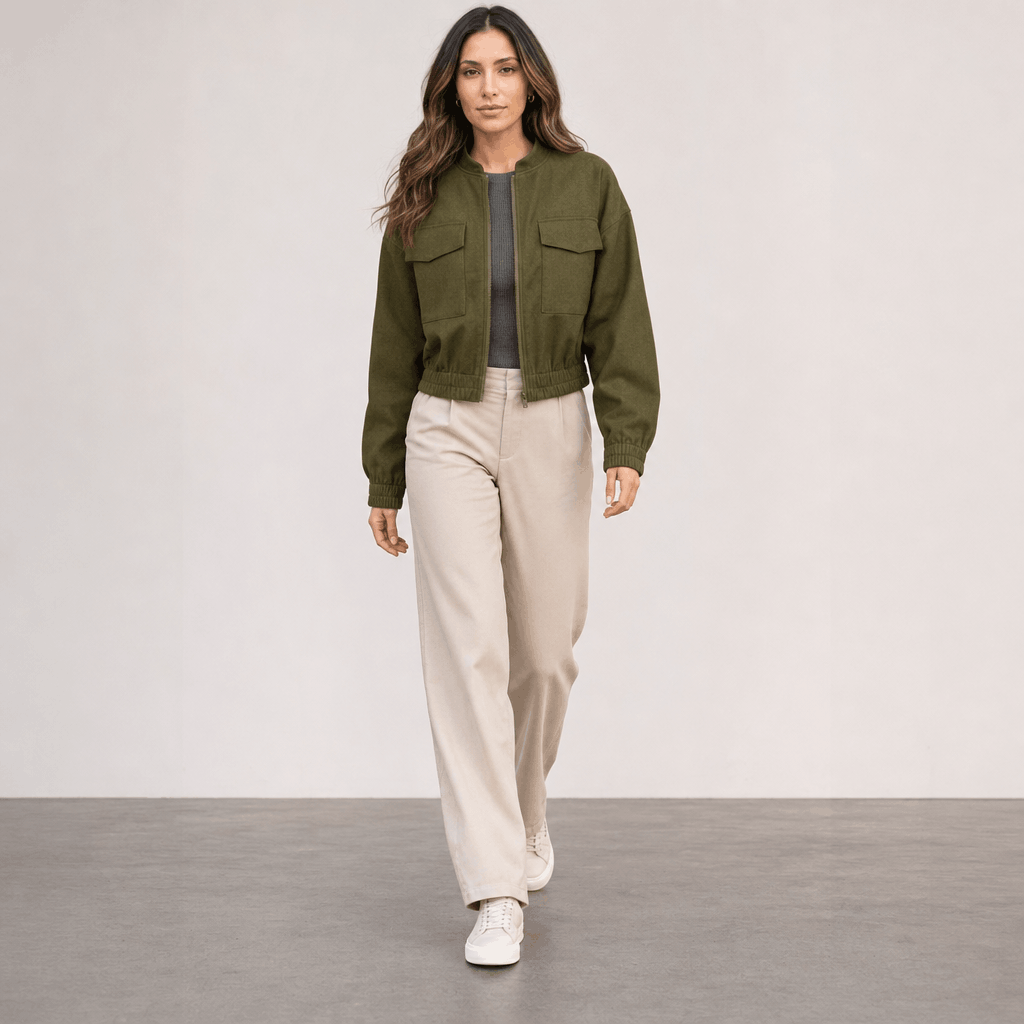 Female model wearing the olive green cropped jacket with cream trousers.