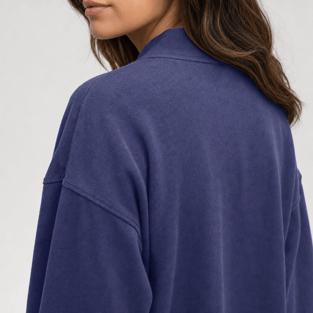 Close-up back view of the blue cropped jacket, showing the collar, shoulder seams, and relaxed fit.