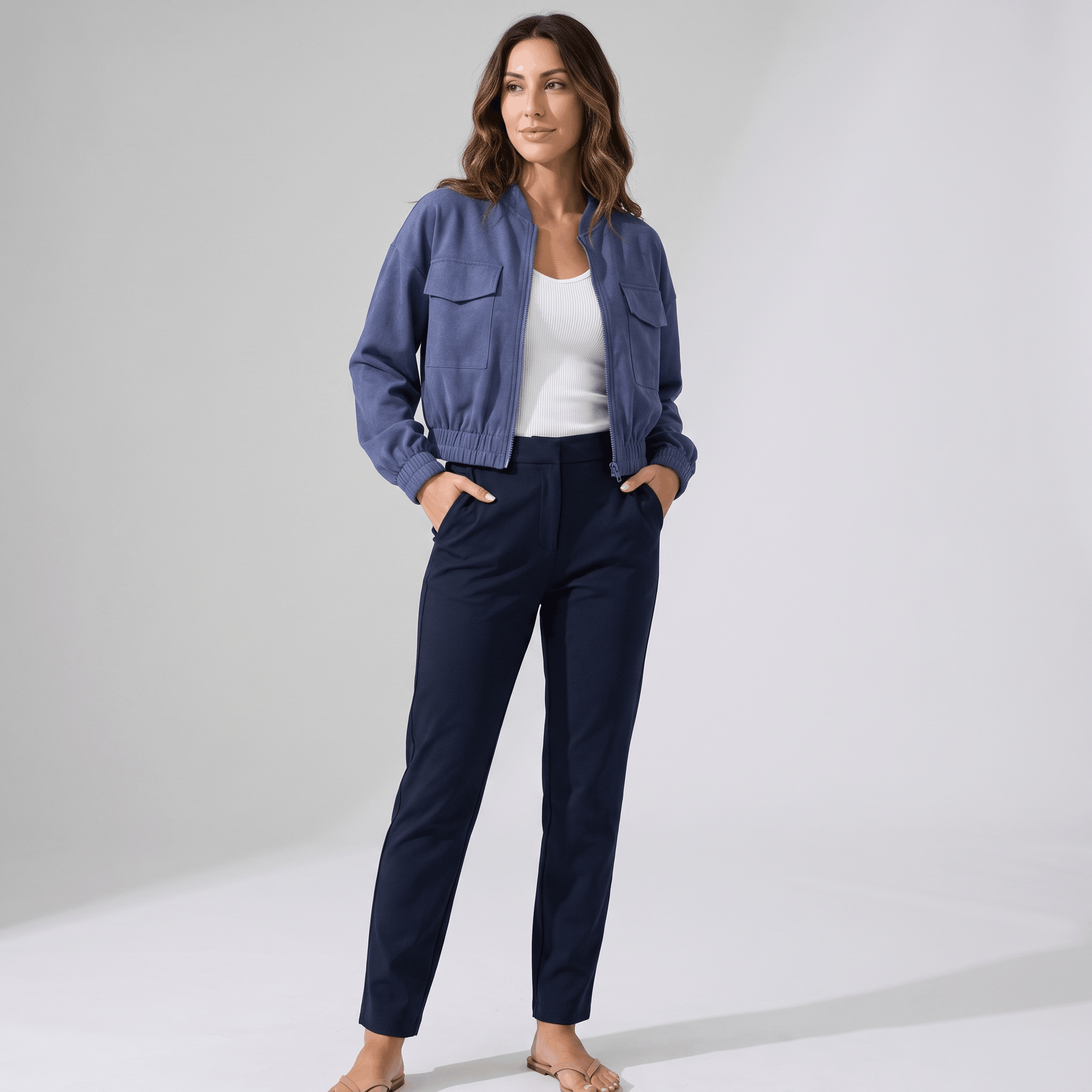 Female model wearing the blue cropped utility jacket with dark blue trousers.
