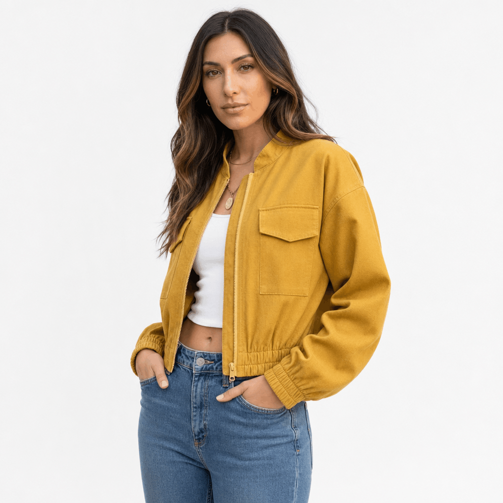 Female model wearing a mustard yellow cropped utility jacket with buttoned chest pockets.