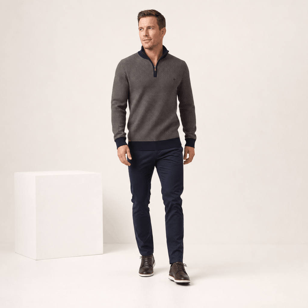 Full-body view of the man wearing the dark gray half-zip sweater with dark pants.