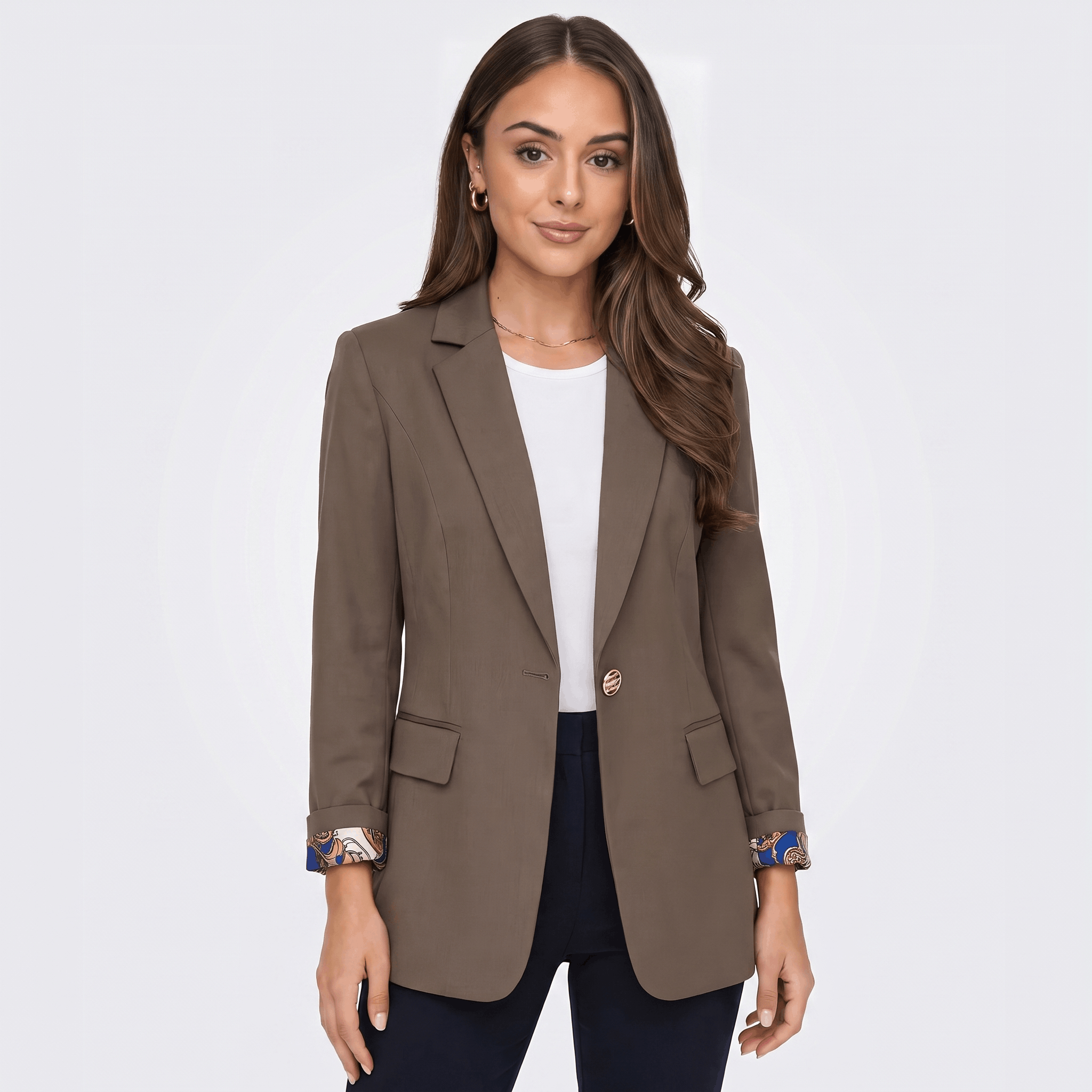 Female model wearing a taupe brown tailored blazer with notched lapels and a single-button closure, paired with dark trousers.