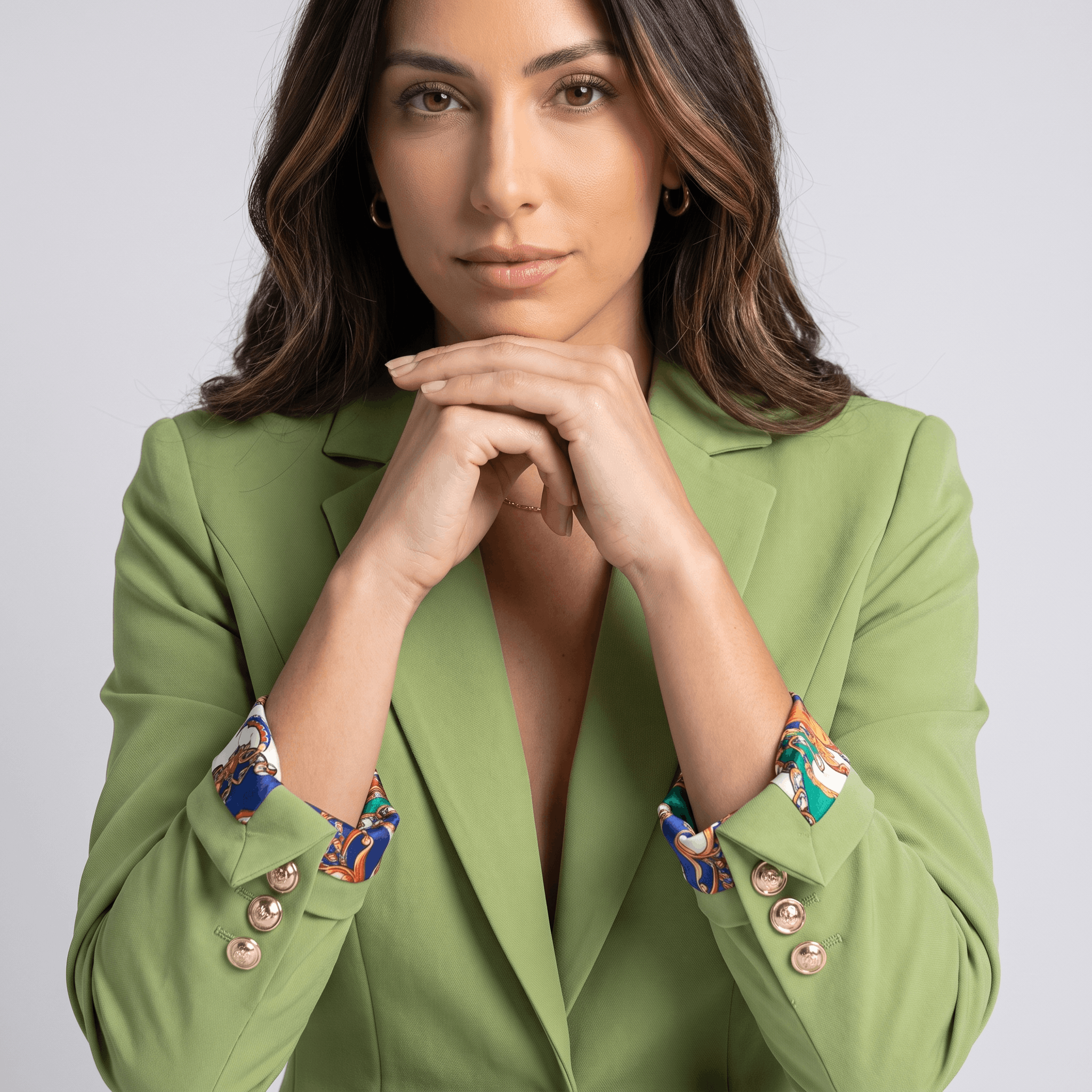 Female model wearing the light green blazer, highlighting the notched lapels, button closure, and patterned shirt cuffs.
