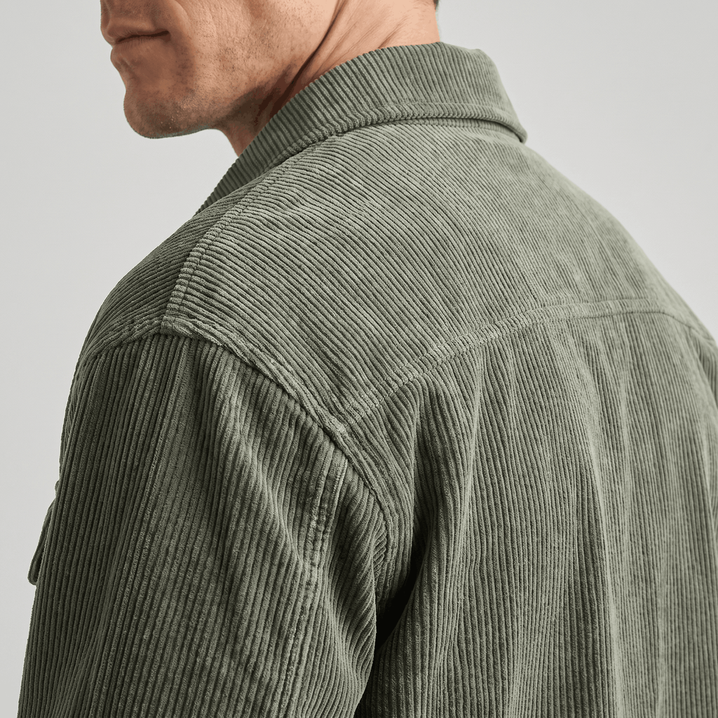 Olive green washed corduroy shirt jacket with a relaxed fit and textured wale, shown from the back shoulder.