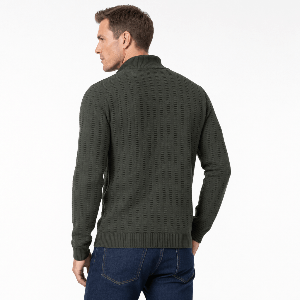 Back view of the man wearing the dark olive green textured half-zip sweater with blue jeans.
