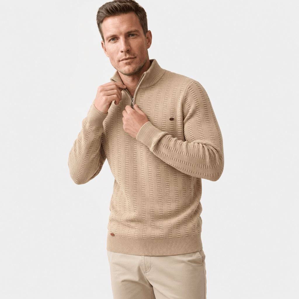 Man wearing a beige textured half-zip sweater with light-colored pants, shown adjusting the collar.