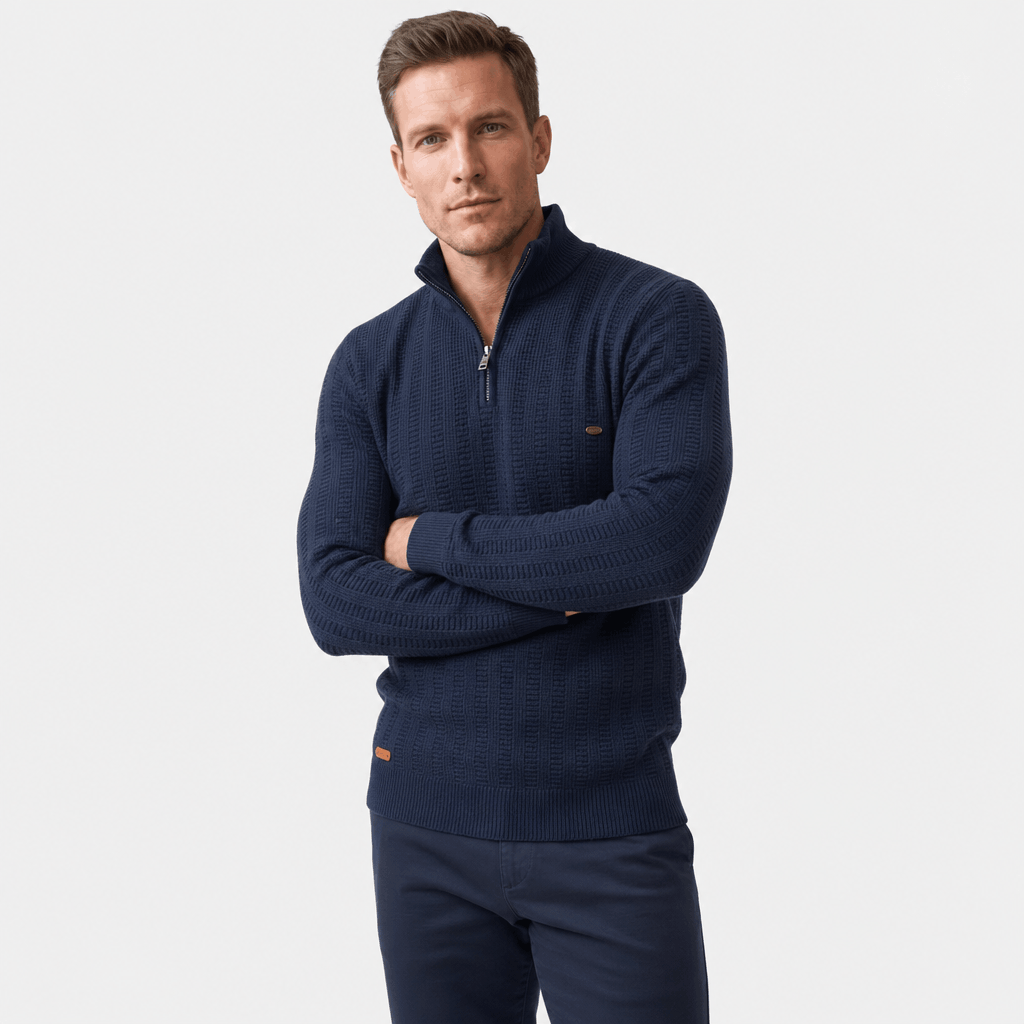 Man wearing a navy blue textured half-zip sweater with dark pants, shown in a front-facing pose with arms crossed.