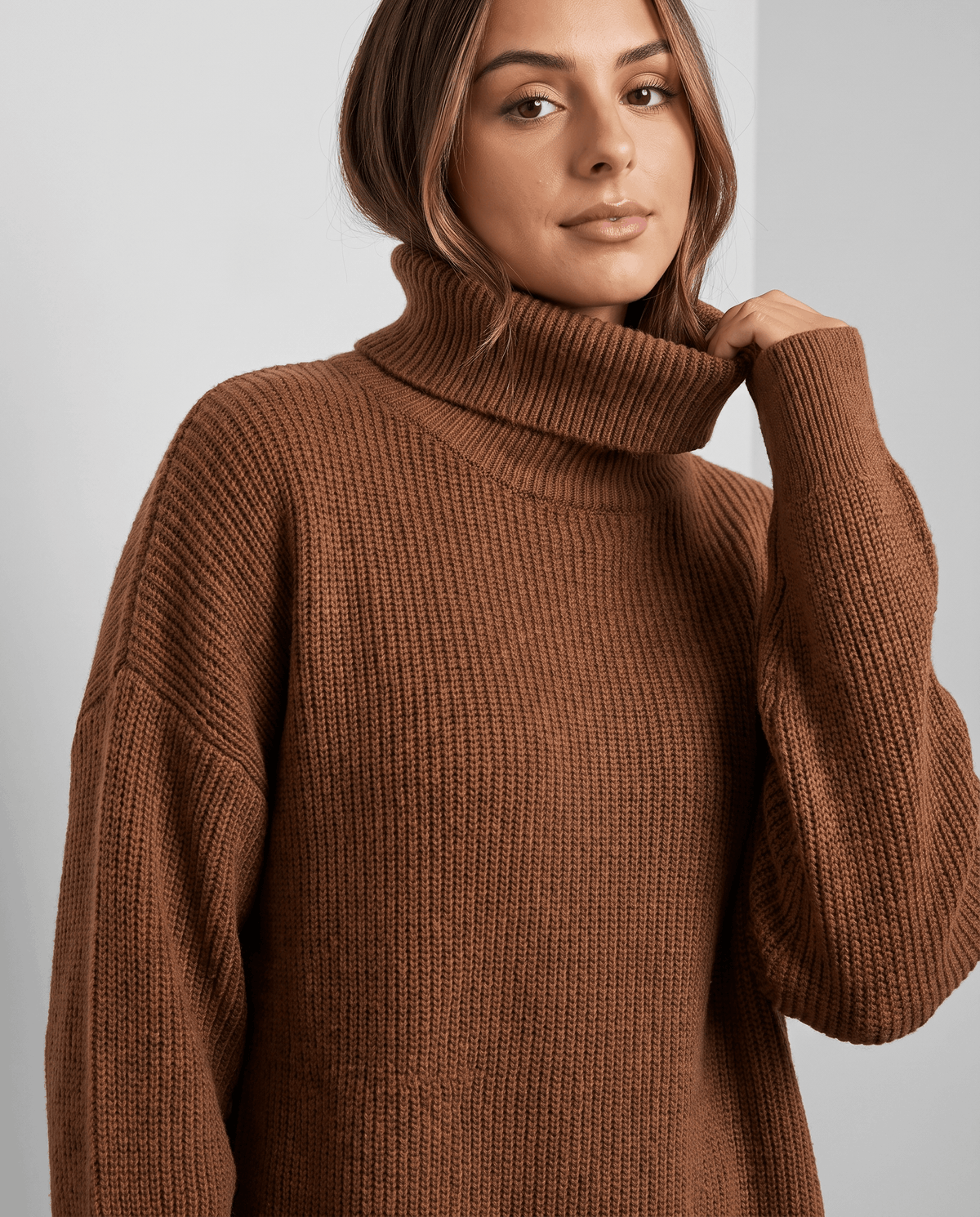 Brown Oversized Longline Sweater worn by a female model, shown from the front with a high turtleneck collar, slouchy fit, long sleeves, and soft knit texture.