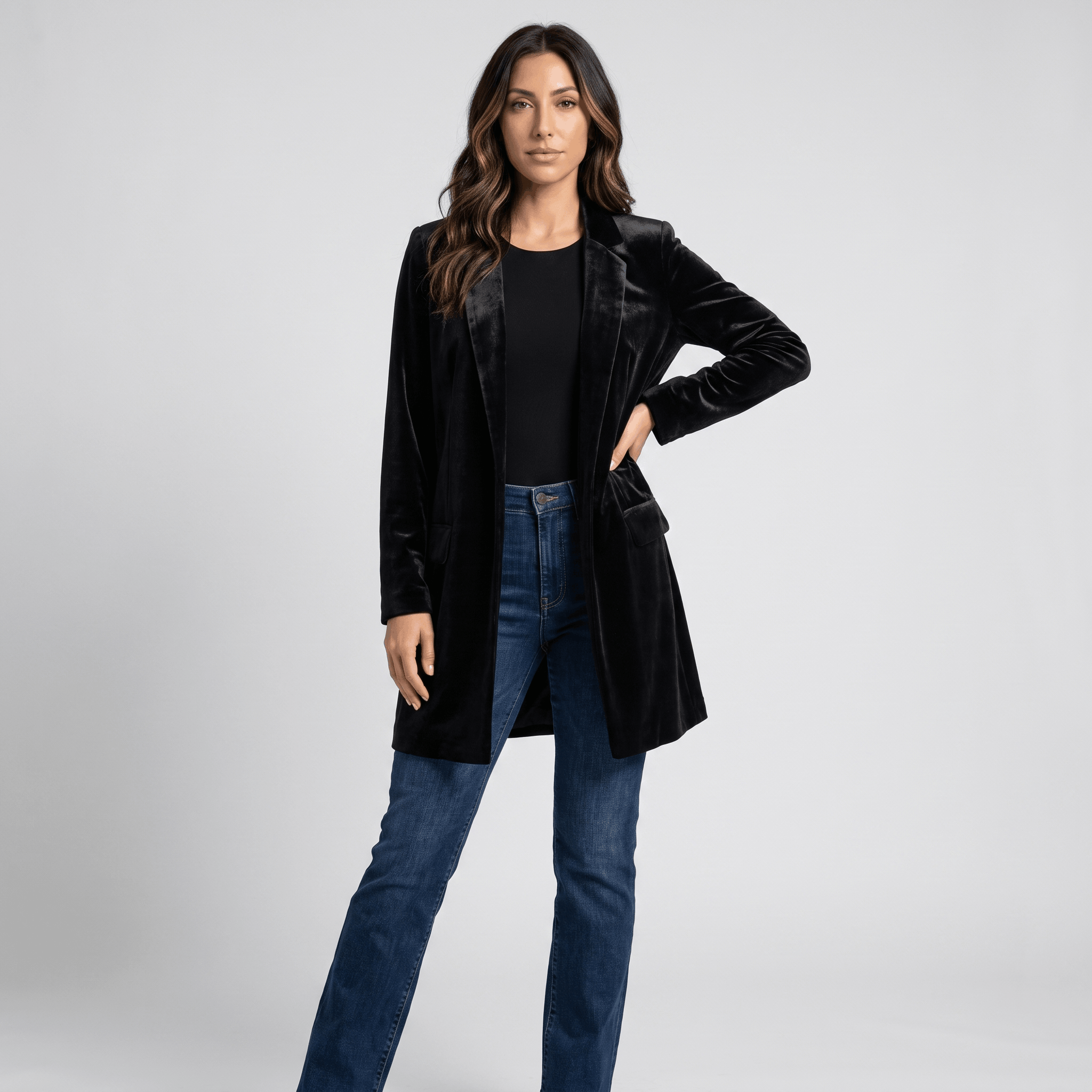 Female model wearing the black velvet blazer coat with a black top and blue jeans.