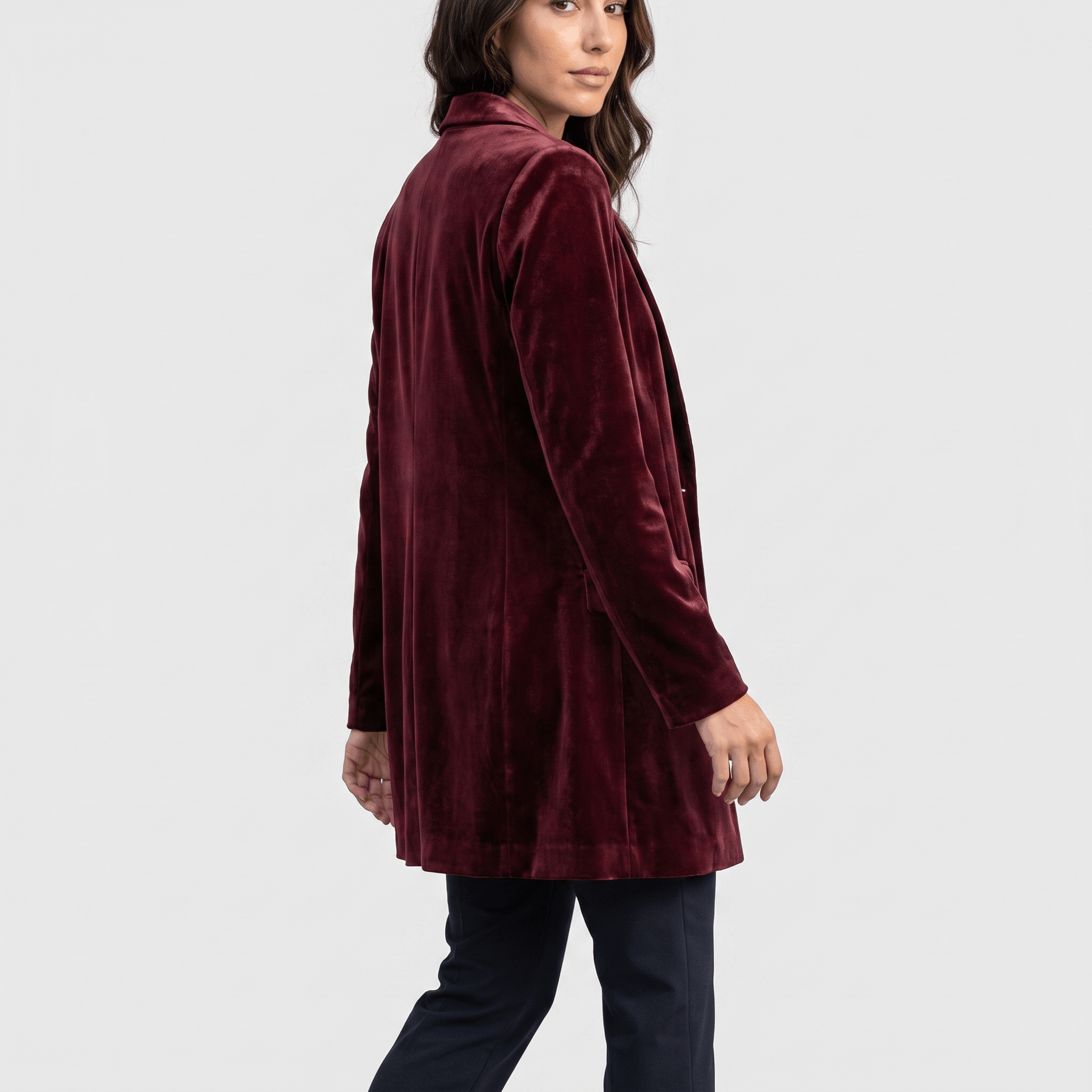 Female model wearing the burgundy velvet blazer, showing the back and fitted silhouette.
