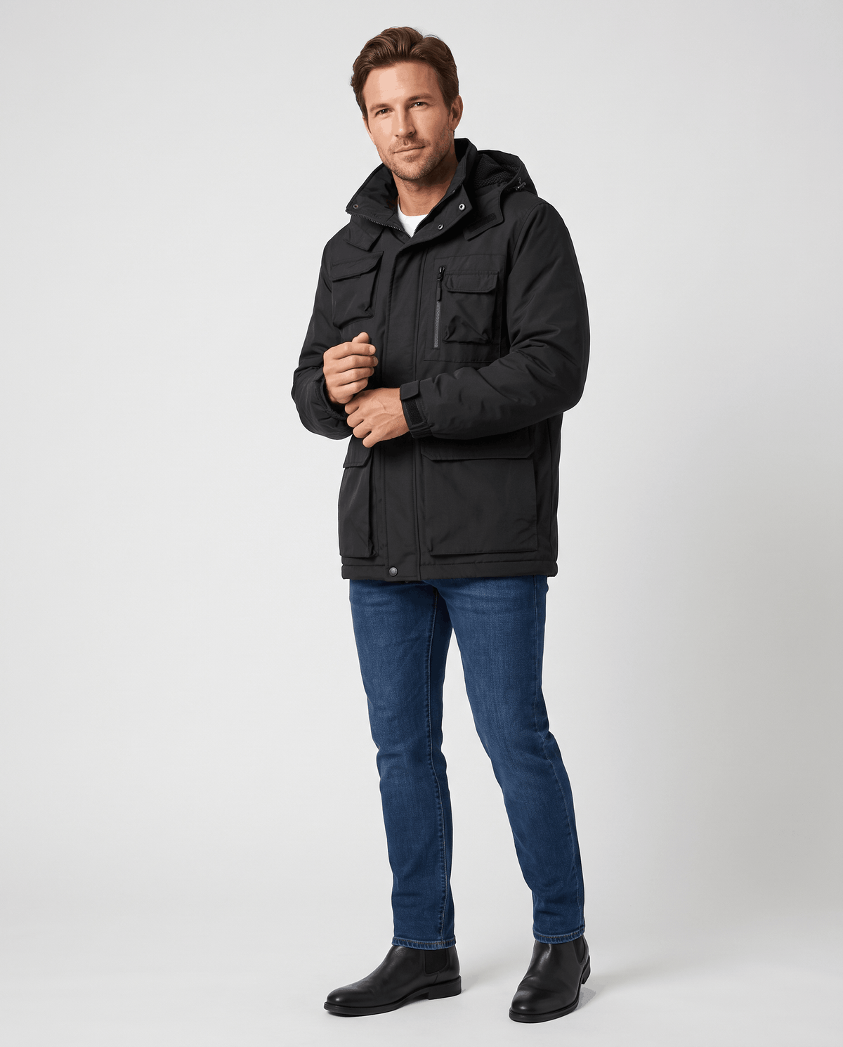 A man wearing a black hooded parka jacket with warm padded lining and multiple front pockets