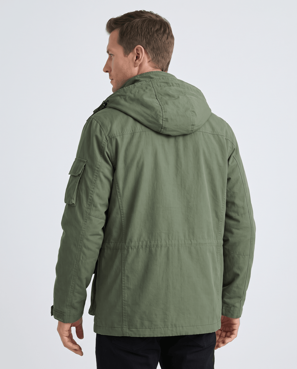 A man wearing a green hooded parka jacket with warm padded lining and multiple front pockets, shown from the back