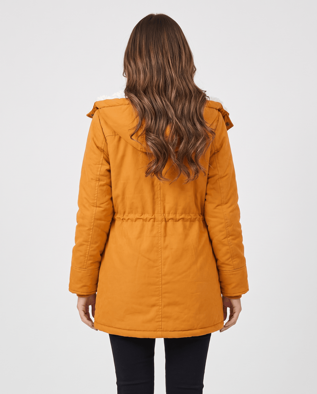 A woman wearing a mustard yellow mid-length parka jacket with plush lining, a hood, and adjustable waist, shown from the back